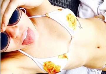 miley cyrus shows flesh in a chicken and waffles print bikini