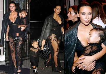 kim kardashian dons plunging racy jumpsuit carries nori at paris fashion week