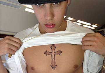 strange justin beiber gets his new tattoo inked on a plane