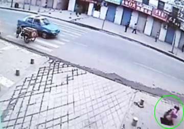 girl on phone accidentally falls through hole in pavement