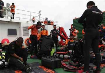 divers enter water in search of wreckage from airasia jet