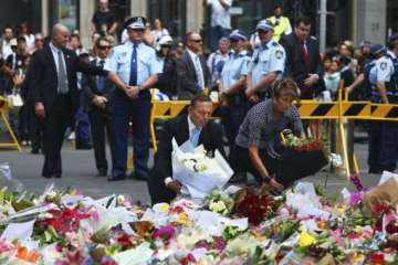 australian pm lays flowers at siege site