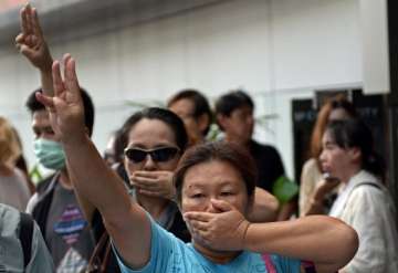 protesters flash hunger games sign at thai pm