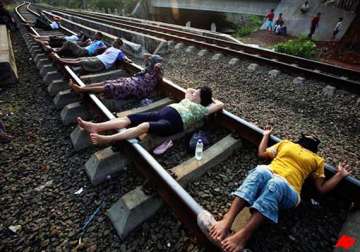 indonesians lie on rail tracks for electric therapy