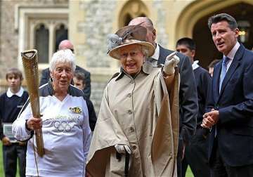 queen greets olympic torch at windsor castle
