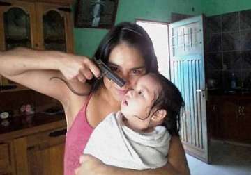 social media aflutter as shocking photograph shows a woman pointing gun at a child