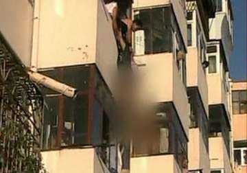 woman pulled to safety after dangling from fourth storey window for 20 minutes