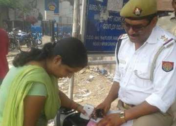 asi sets example issues challan to wife for not wearing helmet