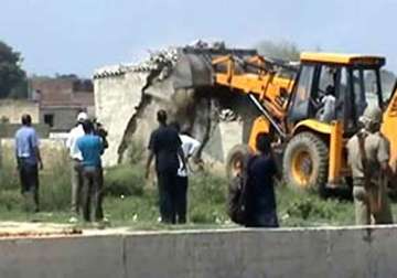 stoning as greater noida bulldozers demolish illegal houses in noida extension green belt