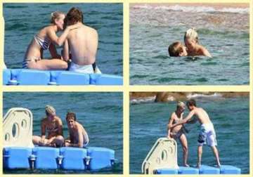 f1 racer vettel gets cozy with his girlfriend at a beach