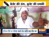 Independent candidate from Buxur Ramchandra Yadav brandishes gun during press conference