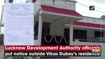 Lucknow Development Authority officials put notice outside Vikas Dubey