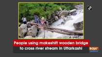 People using makeshift wooden bridge to cross river stream in Uttarkashi