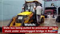 Watch: State bus being pulled by proclainer after it stuck under waterlogged bridge in Rajkot